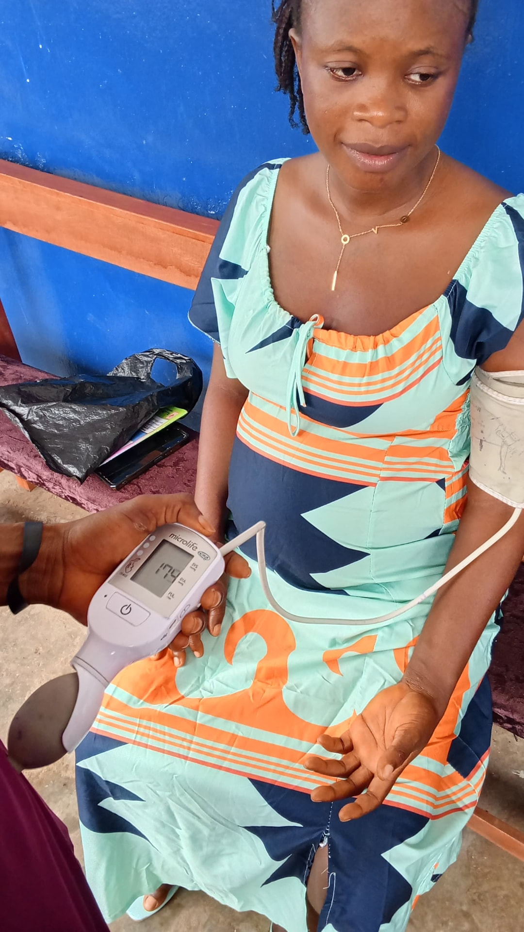 A health worker checking a pregnant woman's blood pressure during maternal care