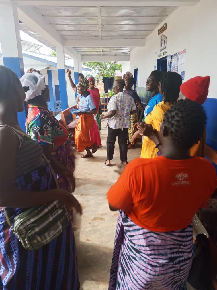 Women gathered together on a health facility veranda during a TMF community activity