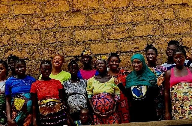 A group of women standing together outside a brick building with a member of the TMF team