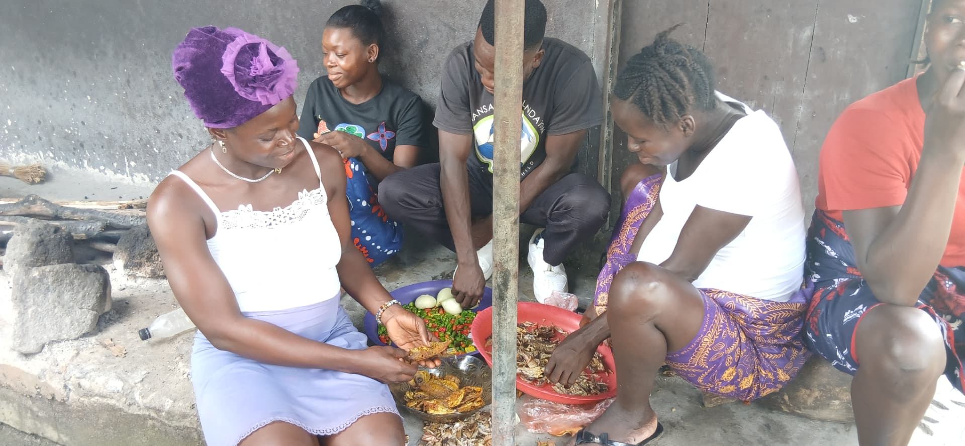 Women and TMF team members preparing food together outdoors