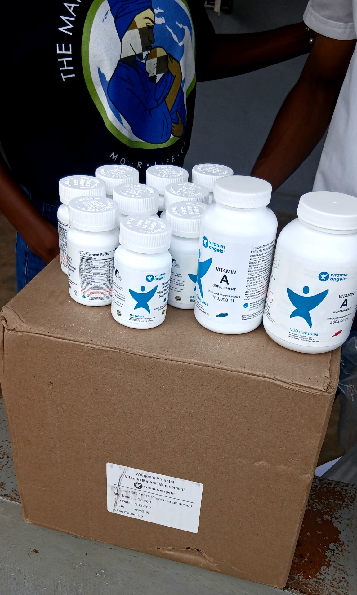 Vitamin Angels bottles arranged on top of a supply box