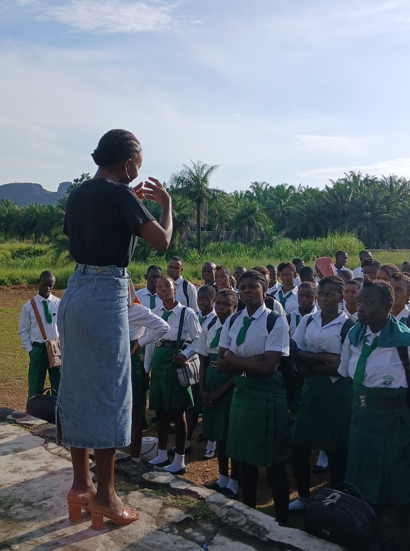 A TMF team member speaking with uniformed students outdoors